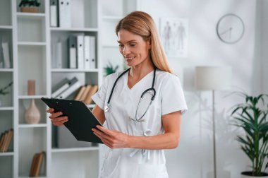 Not defterindeki bilgileri okuyordum. Beyaz önlüklü genç bayan doktor içeride..