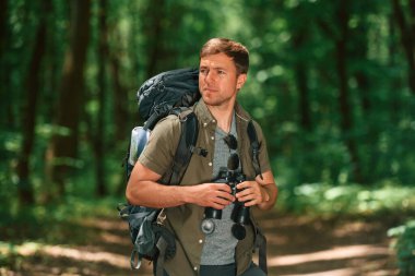 Navigasyon gebeliği. Dürbünle. Yaz ormanında turist.