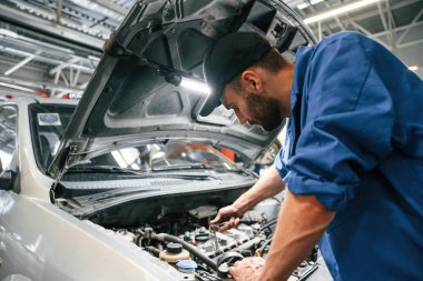 Motor tamiri. Otomobil tamircisi garajda çalışıyor. Onarım servisi.