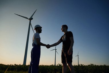 İş adamıyla anlaşma yapmak. Servis mühendisi yel değirmenleriyle sahada..