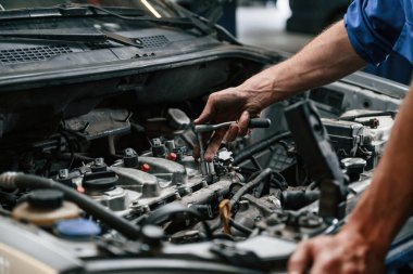 Motor tamiri. Otomobil tamircisi garajda çalışıyor. Onarım servisi.