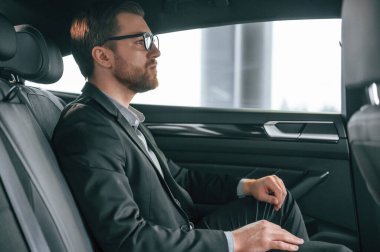 Resmi iş elbiseli adam modern otomobilde oturuyor..