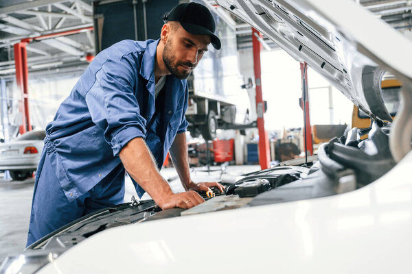 Troubleshooting process. Auto mechanic working in garage. Repair service.