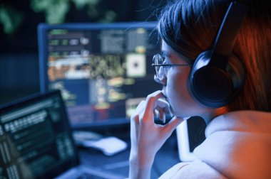 İşine odaklan. Genç profesyonel bilgisayar korsanı bilgisayar başında ve ekranlar hakkında çok fazla bilgiye sahip..