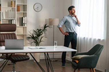 Yürümek, düşünmek, sabırlı olmayı beklemek. Resmi kıyafetli doktor dolapta çalışıyor..