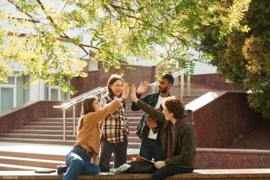 Çak bakalım. Gündelik giysiler içinde dört genç dışarıda beraberler..