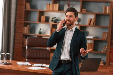 Telefonla aktif konuşma. Resmi kıyafetli bir iş adamı içeride çalışıyor..