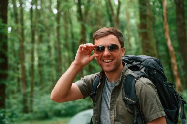 Güneş gözlüklü. Yaz ormanında bir turist. Keşif ve eğlence kavramı.