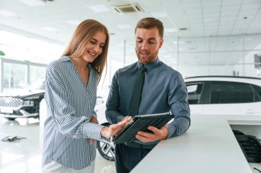 Not defterindeki bilgiler. Resmi elbiseli adam elektrikli arabalı kadın müşteriyle birlikte..