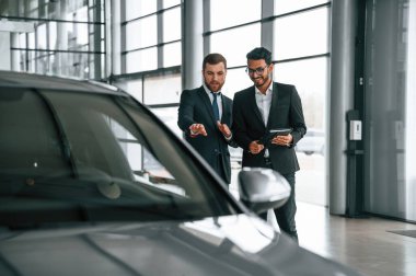 Araca bakıyorum. Adam galeride müşteriye danışıyor..