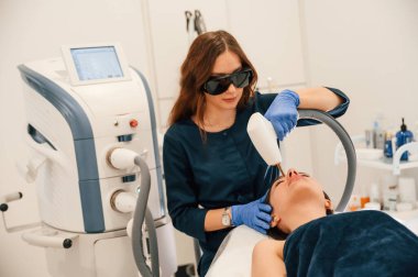 Uzanmak. Kozmetik Kliniğinde fotoğraf gençleştirme prosedürü alınıyor.