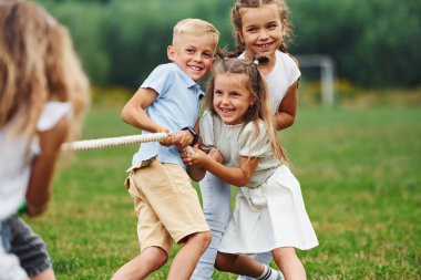 Gülümsüyor, savaş oyunu oynuyor. Çocuklar gündüz vakti sahada eğleniyorlar..