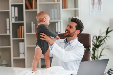 Çocuk ellerde. Küçük bebekli doktor dolapta çalışıyor..