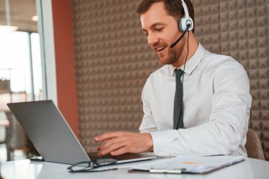 Laptop kullanıyorum. Resmi giyinmiş yakışıklı adam büroda..