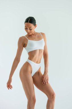 İnce vücut tipi. Genç kadın stüdyoda spor kıyafetleri giyiyor..