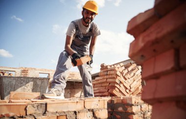 Gündüz vakti dışarıda. Yakışıklı Hintli adam şantiyede..