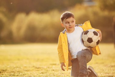 Ön manzara. Oğlan futbol topuyla yaz sahasında..