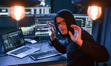 Yakalandım. Ellerini kaldır. Erkek profesyonel hacker bilgisayar başında oturuyor, virüs kavramı..