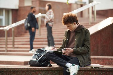 Gündelik giysiler içindeki genç öğrenciler açık havada birlikteler..