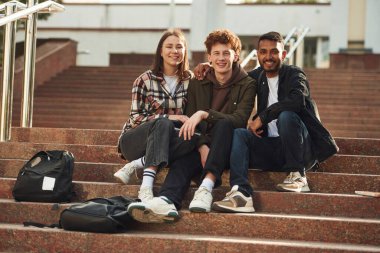 Kameraya bakıyorum. Gündelik giysiler içindeki genç öğrenciler açık havada birlikteler..