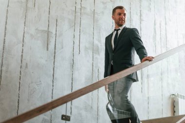 Takım elbiseli ve kravatlı adam merdivenlerde..