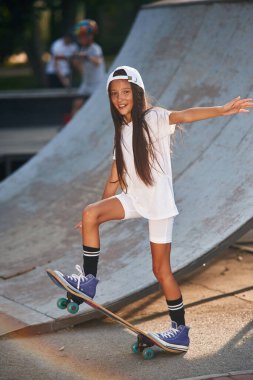 Rampanın yanında kaykay sürüyordum. Mutlu küçük kız açık havada.