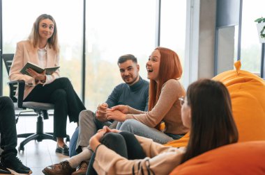 Psikolog oturuyor ve dinliyor. Bir grup insan terapi toplantısındalar..