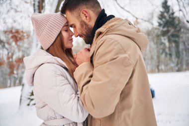 Aşk kavramı. Çiftler kış ormanlarında yürüyüşe çıkar..
