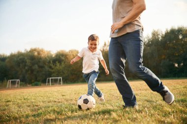 Nasıl futbol oynanacağını öğreniyorum. Baba ve küçük oğlu dışarıda eğleniyorlar..