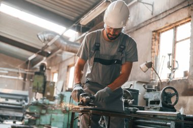 Yoğun bir gün. Gri üniformalı genç fabrika işçisi.