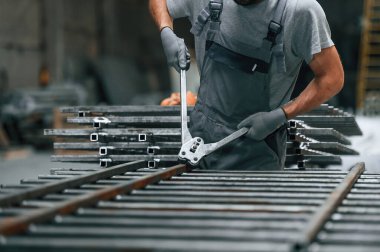 Metal ürünü kesmek için makas kullanmak. Fabrikada çalışan adamın yakın görüntüsü..