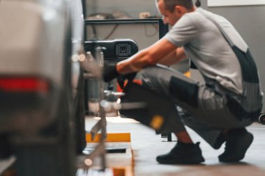 Lastiği değiştiriyorum. Adam otomobil tamirhanesinde çalışıyor..