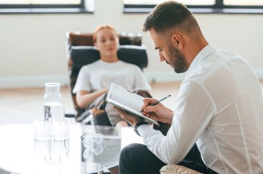 Hayat sorunları. Kadın bir psikologla randevuda sandalyede oturuyor..