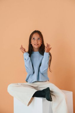 Küpte oturup dua etmek. Şirin genç kız stüdyoda arka planda..