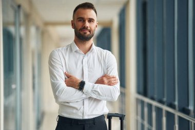 Kollarını kavuşturmuş duruyorsun. Havaalanında genç yakışıklı bir adam var..