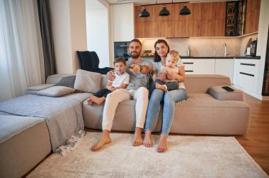 Ön manzara. İki küçük çocuklu ebeveynler evcil odada birlikteler..