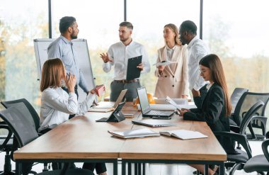 Toplantıda, planları tartışıyorduk. Bir grup ofis çalışanı içeride birlikte..