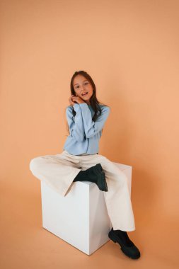 Şirin genç kız stüdyoda arka planda..