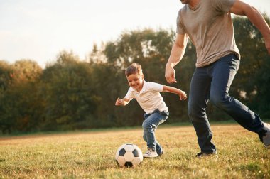 Nasıl futbol oynanacağını öğreniyorum. Baba ve küçük oğlu dışarıda eğleniyorlar..