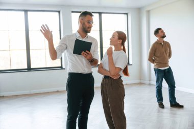 Emlakçı genç bir çifte bir daire gösteriyor..