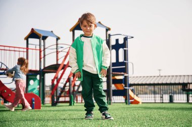 Ön manzara. Çocuklar oyun alanında eğleniyor..