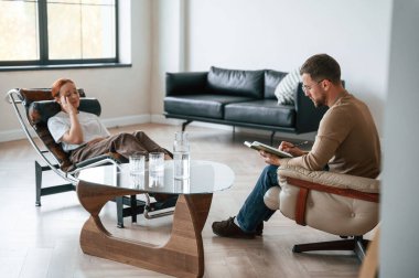 Hastaya yardım ediyorum. Kadın bir psikologla randevuda sandalyede oturuyor..
