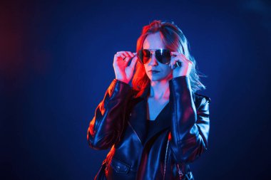 Güneş gözlüklü. Neon renkli güzel bir kadın portresi..