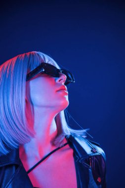 Orta boylu, beyaz saçlı. Kadın neon renklerle stüdyoda..