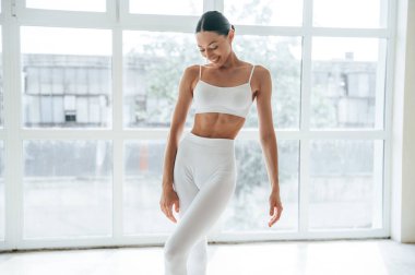 Spor elbiseli kadın pencerenin önünde dikiliyor..