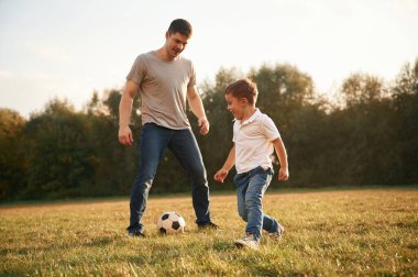 Futbol maçı kavramı. Baba ve küçük oğlu dışarıda oynuyor ve eğleniyorlar..