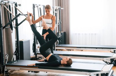 Bacakları havada. Spor salonundaki kadınlar egzersiz yapıyor..