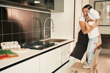 Lavabonun yanında. Anne ve kızı mutfakta yemek hazırlıyorlar..