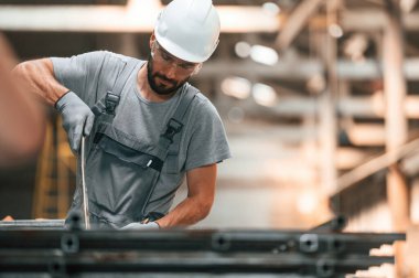 Yakışıklı bir adam. Gri üniformalı genç fabrika işçisi.