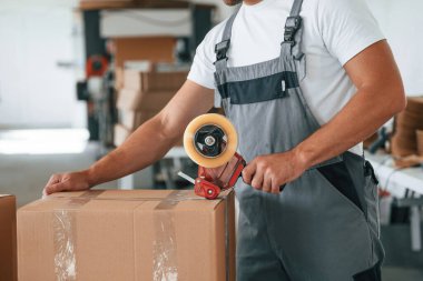 Ürünü paketliyorum. Yakışıklı adam ekolojik kutular üreten fabrikada çalışıyor..